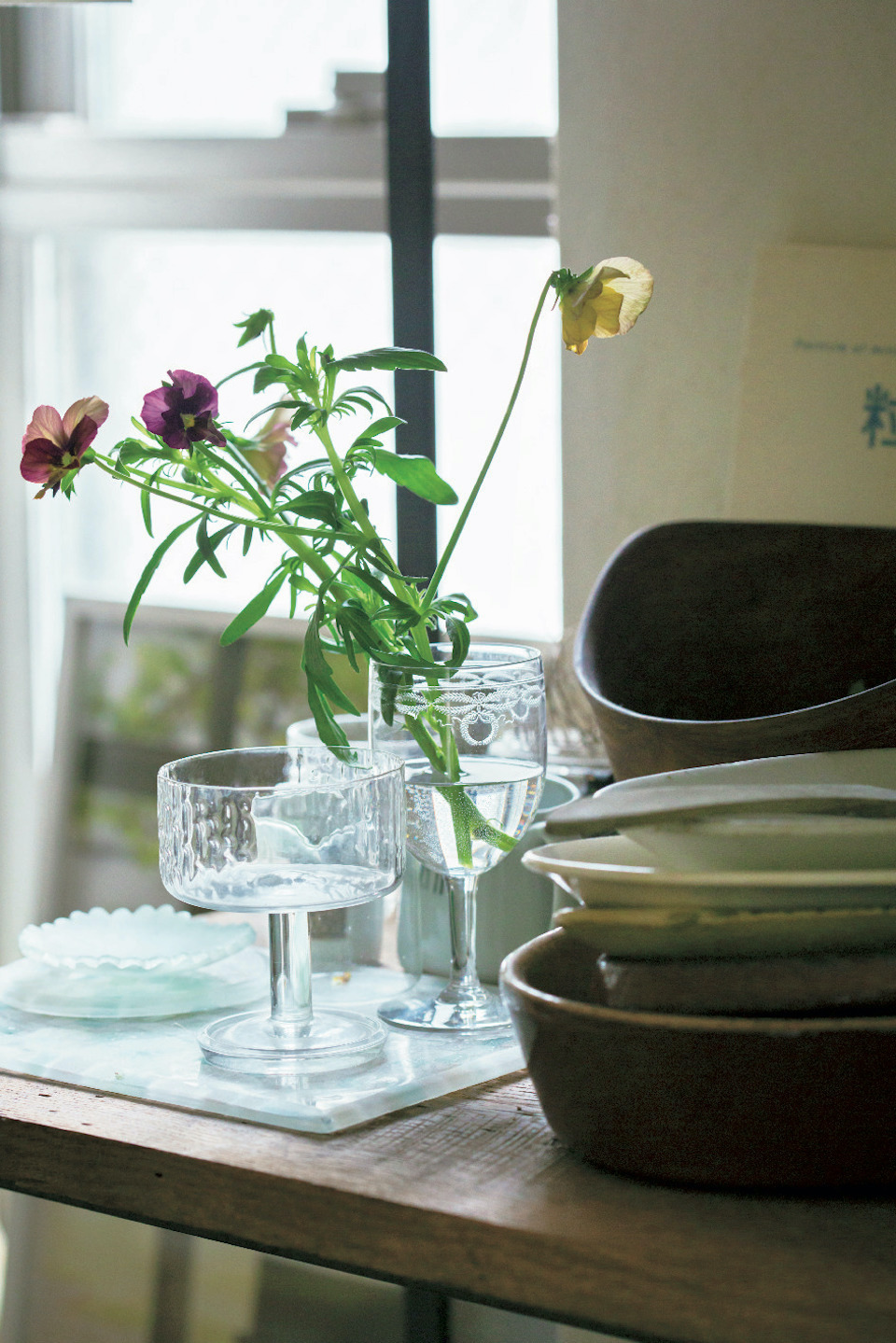 小さな頃から草花とともに暮らす日常を過ごして きた鈴木さんは、野に咲くような花を 1 種類でバ サッと生けるのが好み。フランスの蚤の市で「レ リーフの美しさや繊細な佇まいに惹かれた」とい うアンティークグラスには、大好きなヴィオラを。