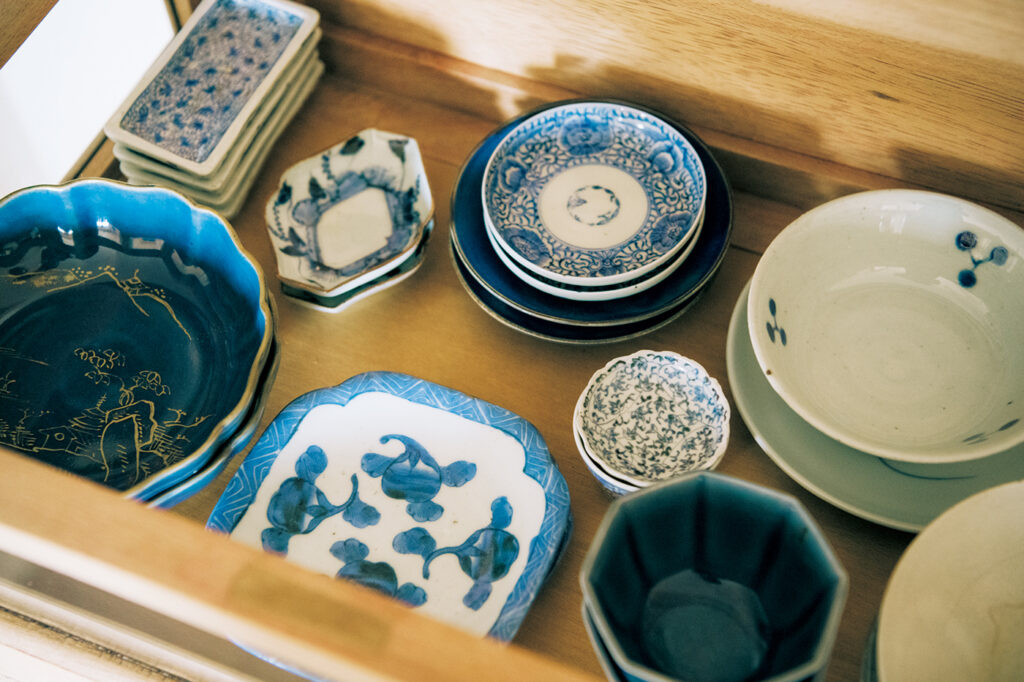 フランスのアンティーク棚の引き出しに収められた染付や瑠璃釉の器。小皿は釉薬の色別に収納。骨董だけでなく現代ものも。