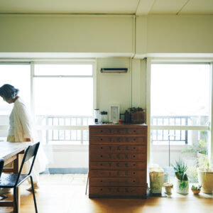 東南向きのリビング。中央は手芸店が店じまいのときに譲ってくれた業務用収納棚。テーブルは学校の図工用作業台をネットオークションで。