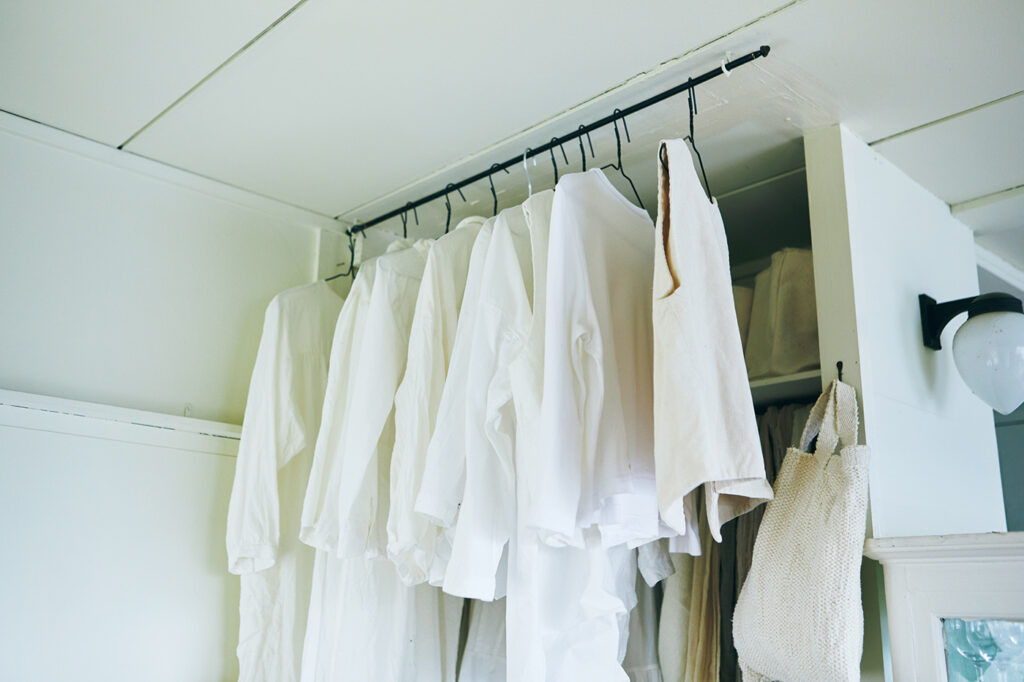 布作家の山中とみこさん宅のリビングの端には、天井近くに白い服だけが吊るしてある。白は視界に入っても圧迫感がない。
