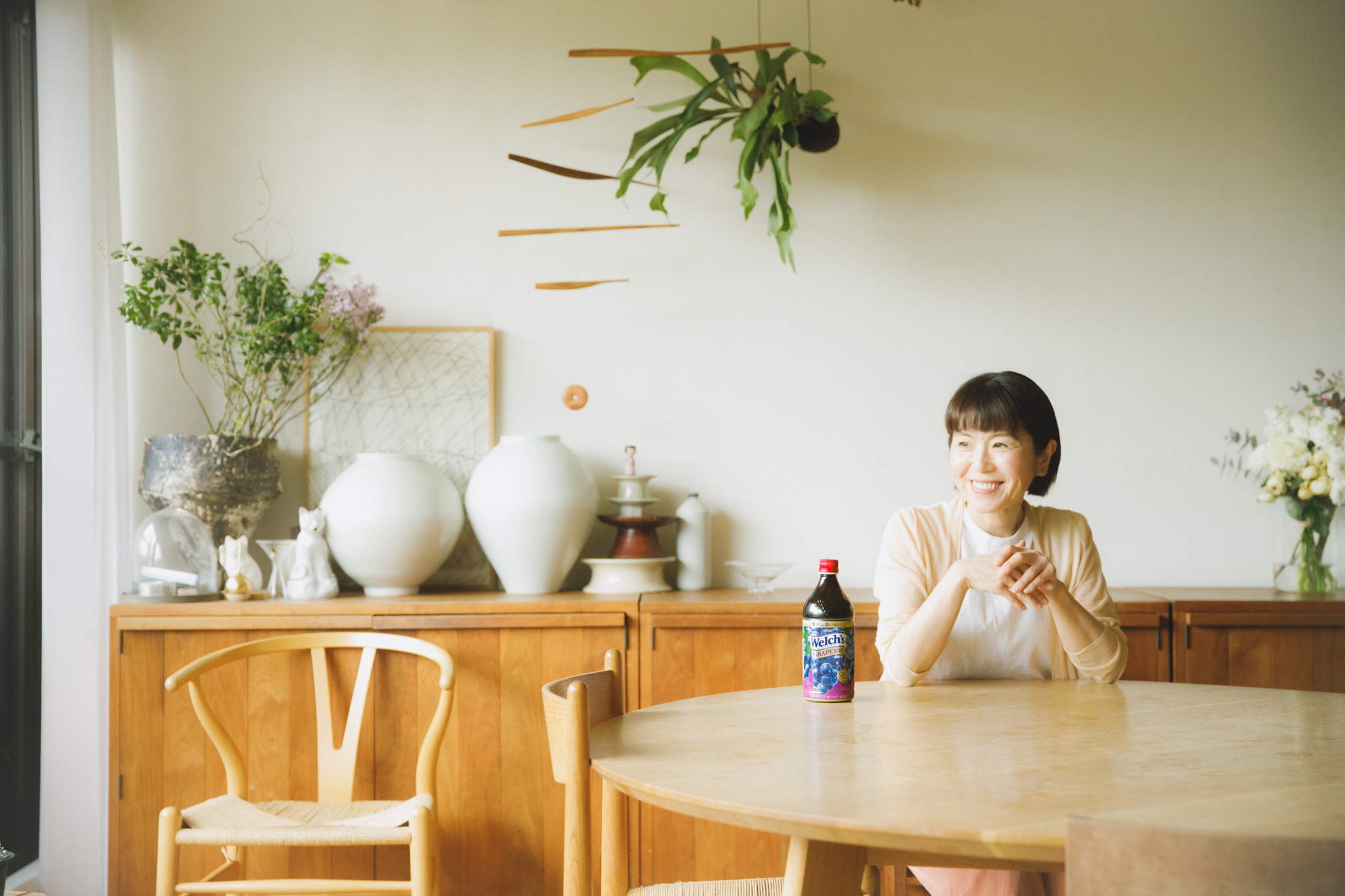 仕事がひと段落した昼下がり、ダイニングから外を眺める料理家のワタナベマキさん。ほっと一息つく時間に寄り添ってくれるのが「Welch’s グレープ100」。