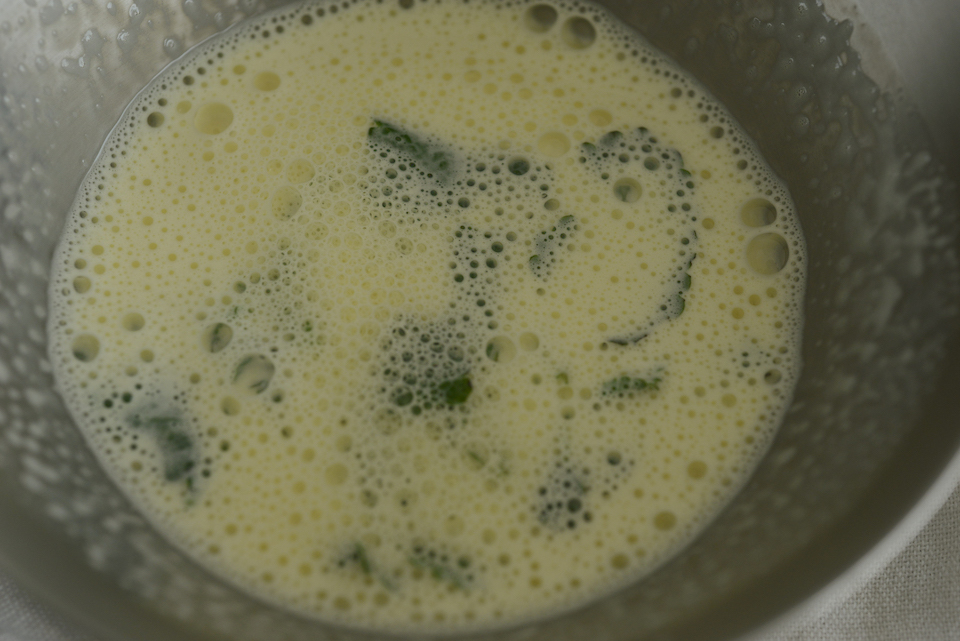 2. 鍋に牛乳とレモンバームを入れ、沸騰したら火を止める。「1」のボウルに加え、ホイッパーでよくすり混ぜる。