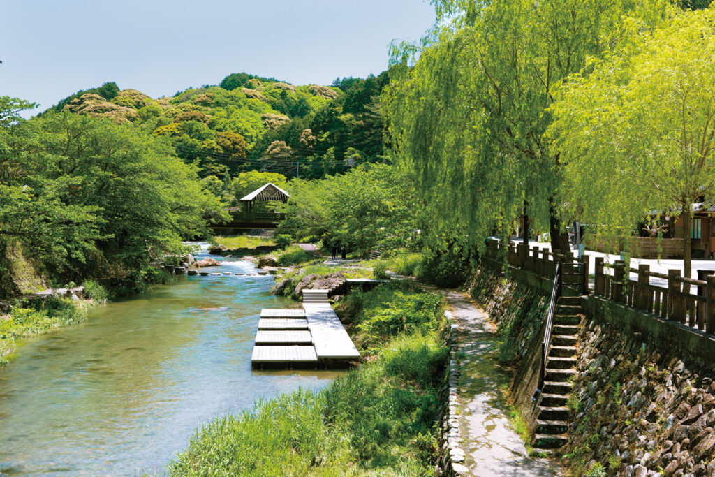 音信川のせせらぎを間近に感じられる星野リゾートの温泉旅館『界 長門』の川床テラス。春には川沿いの桜が咲き、夏には川遊びをする子どもたちも訪れて賑やかに。