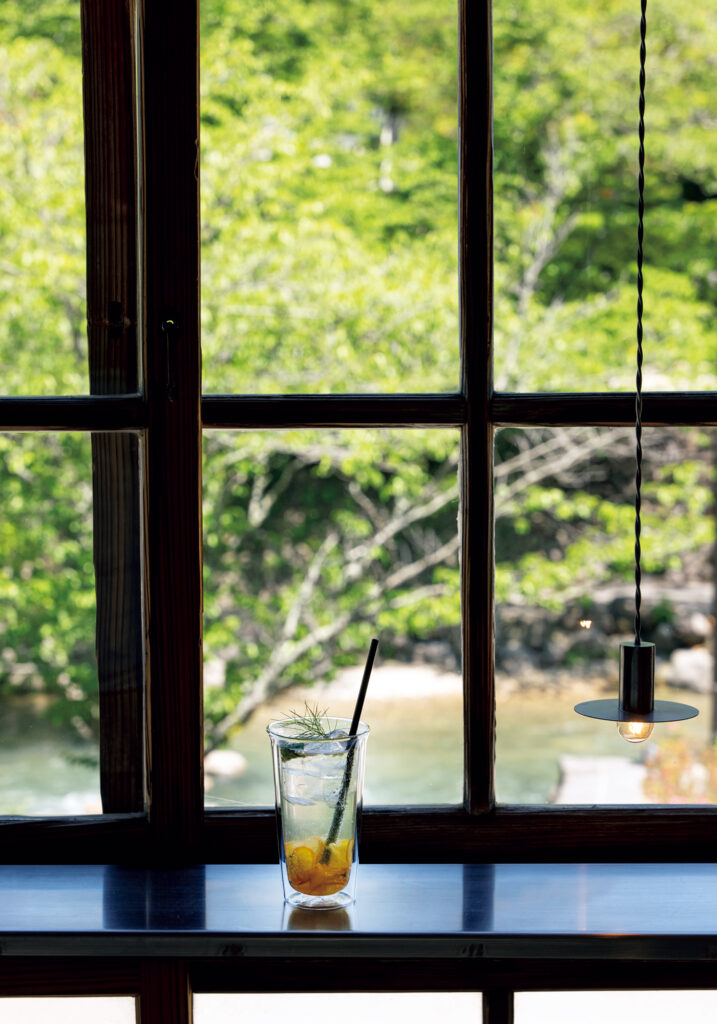音信川を間近に見下ろす『cafe and shop Tre』のカウンターは特等席。季節のシロップのソーダ（￥715）のほか、カレープレートランチ（￥1,200）も人気。