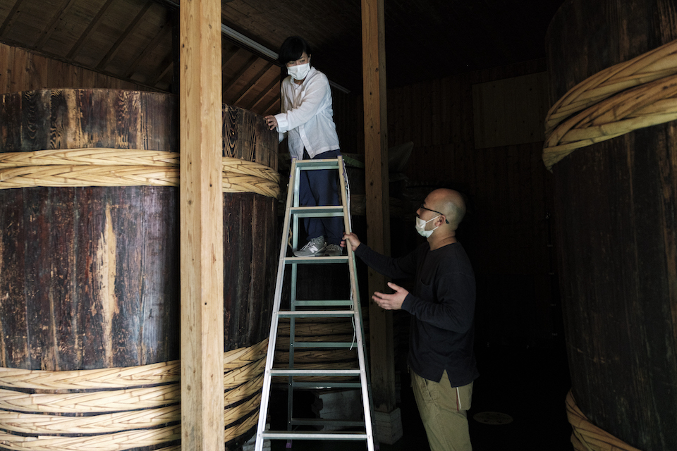 自家醸造を復活させた〈ミツル醤油醸造元〉４代目の城慶典さんに、醤油樽を覗かせてもらう。