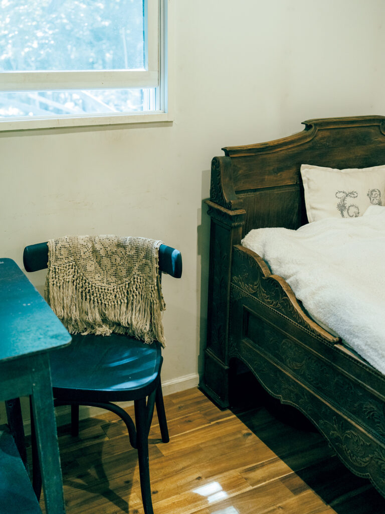 「古びた感じがこの家には合う」という寝室の木製ベッド。アンティークレースは何枚か所有。