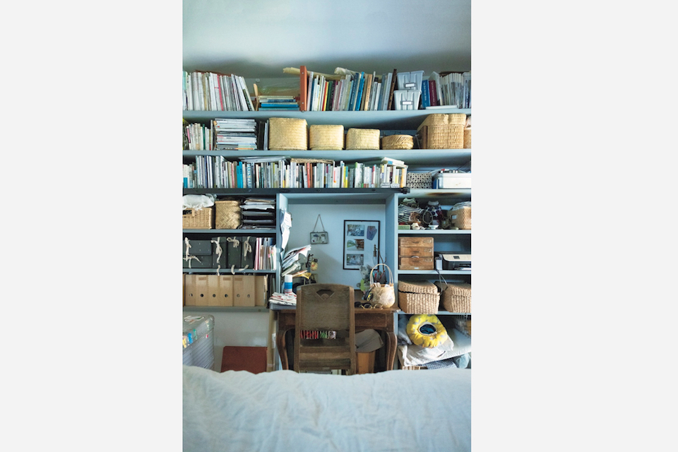 寝室の壁面は机を囲むように本棚と収納棚。机は天板を切ってもらって収めた。