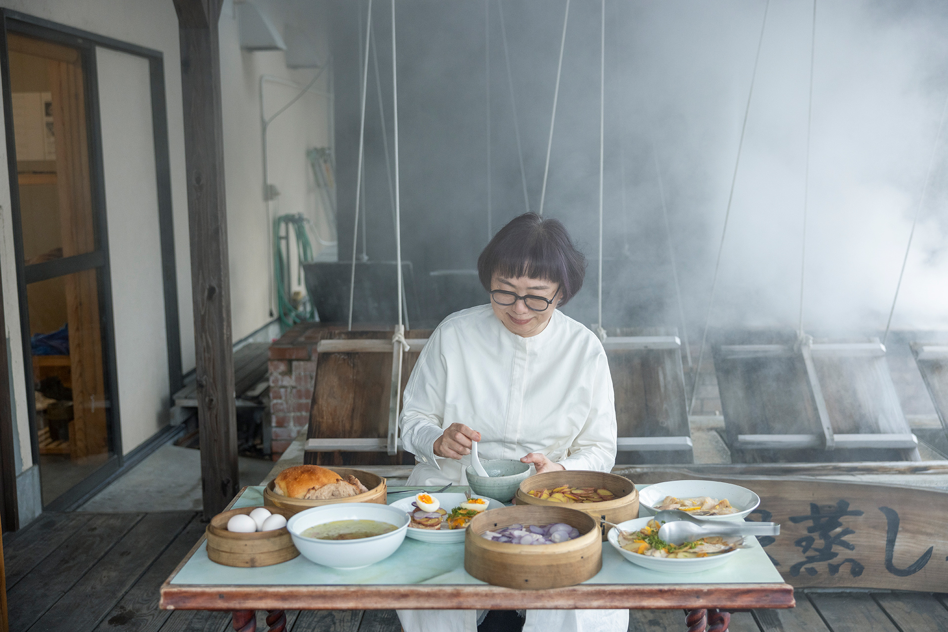 湯気に包まれて、念願の”蒸し釜”料理を楽しむ福田さん。「自宅の蒸し器では真似ができない、ここだけのおいしさです」