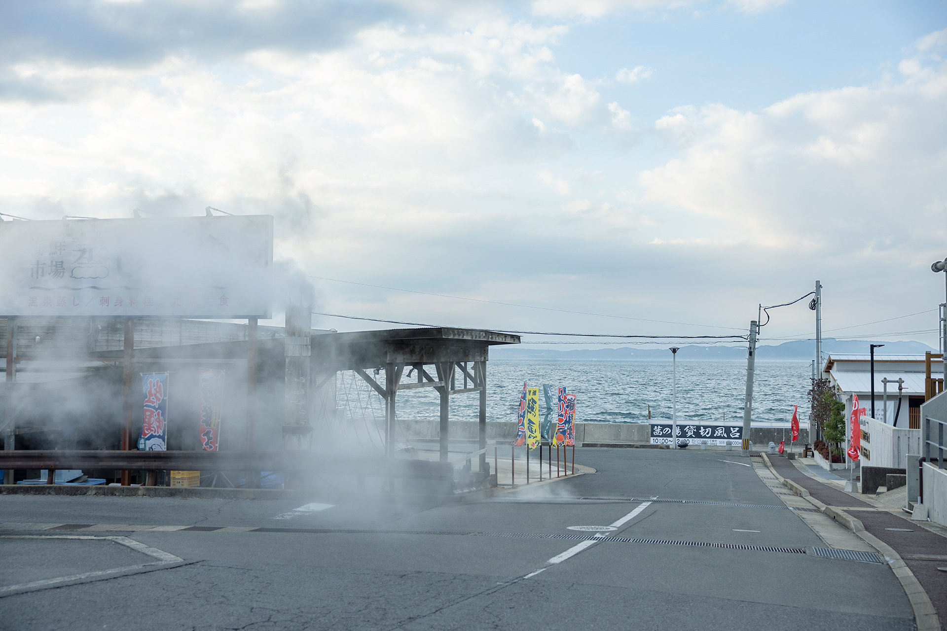 海と湯気が織りなす小浜温泉ならではの風景。公共浴場や足湯が連なる。