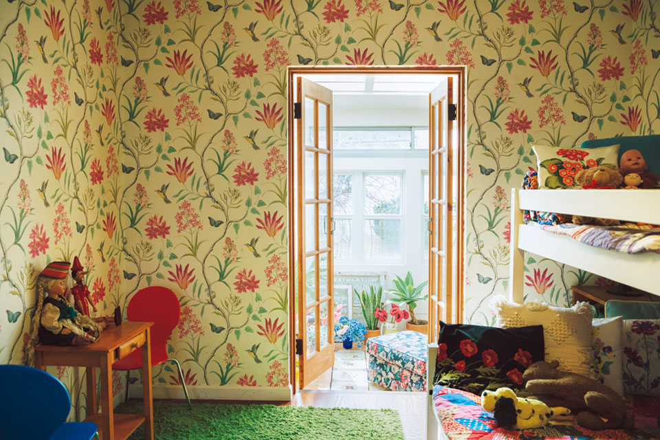 仲良し姉妹の部屋は、壁紙のボタニカル柄が目を引く。クッションなども花柄で。家の中すべてに植物が満ちているイメージ。