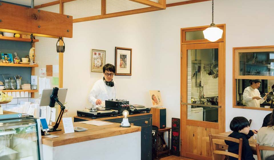 近所のファミリーが朝食を楽しむ脇で、DJプレイ中の矢澤和久さん。「かかっている曲をきっかけにお客さんと会話ができたらと、プレイ中のレコードジャケットはスピーカーの上に」