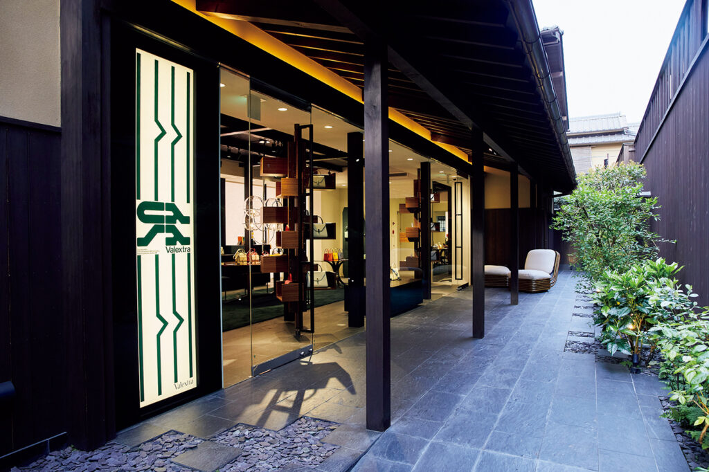 町家らしい”鰻の寝床”な、奥行きのある木造2階建て建築。軒先にはミッドセンチュリーのデザイナー、ガブリエラ・クレスピの「ボヘミアン72ラウンジチェア」が。Meet the Design & Crafts in Kyoto Casa Valextra ヴァレクストラ 京都 旅