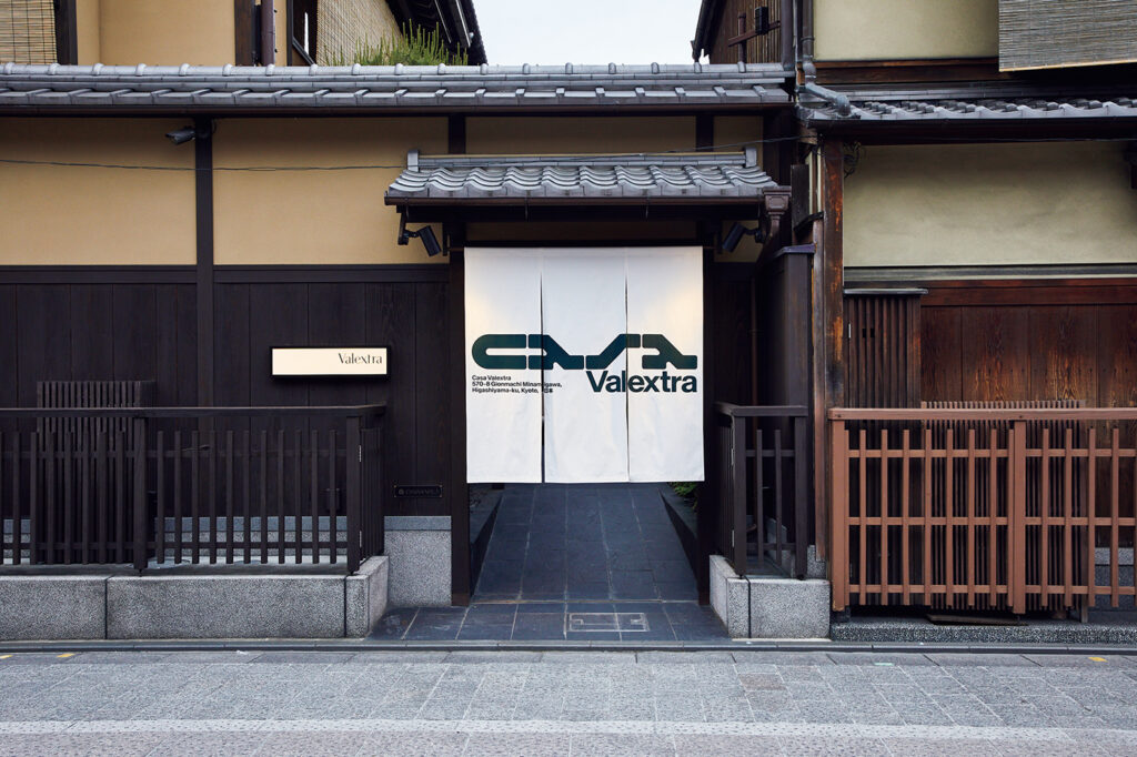 〈ヴァレクストラ〉のアイコンカラー・緑を使ったミニマルなタイポグラフィが目を引く、軒先の暖簾が目印。Meet the Design & Crafts in Kyoto Casa Valextra ヴァレクストラ 京都 旅