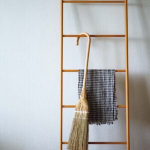 掛けほうき_掃印 オモムロニ。 | 掛けほうき_掃印
オモムロニ。さんが〝ササッと掃除するときに重宝している〞という箒はハンドル付きのステッキ型。「壁やドアに掛けられて便利。柄が長いので、腰を屈めずに床を掃けます。佇まいが美しいので、しまいこまずに目につくところに引っ掛けておきたくなりますね」。吊り下げておけば、穂先に癖がつきにくい。作者は白木屋傳兵衛で修業した箒職人の鈴木徹。