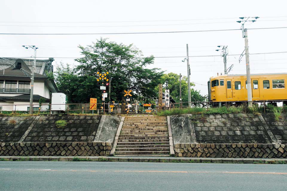 神社の参道が続く中を道路と電車が横切る不思議な光景もまた尾道らしい。