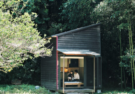 里山の自然に包まれた約３坪の小屋は、榎戸勇人さん家族の離れの寝室。妻の真生さんと、昼寝から起きた１歳の長女かやちゃんがいる。セルフビルドの小屋キット「KOKON」を利用して建てた。