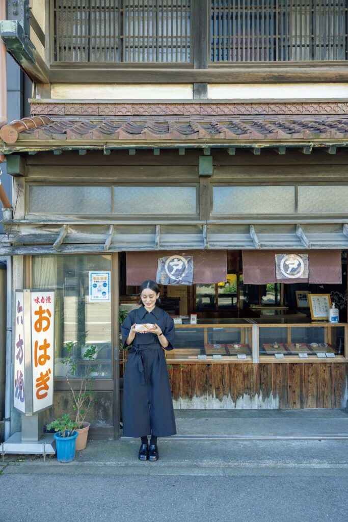 Sakiko Hirano
フードエッセイスト。著書『生まれた時からアルデンテ』（平凡社）をはじめ、雑誌、文芸誌で執筆。菓子屋『ノーレーズンサンドイッチ』も手がけている。ポッドキャスト＆ラジオ番組『味な副音声』も好評配信中。金沢でのお菓子巡りは今回が初めて。写真は、『戸水屋』の店先にて。