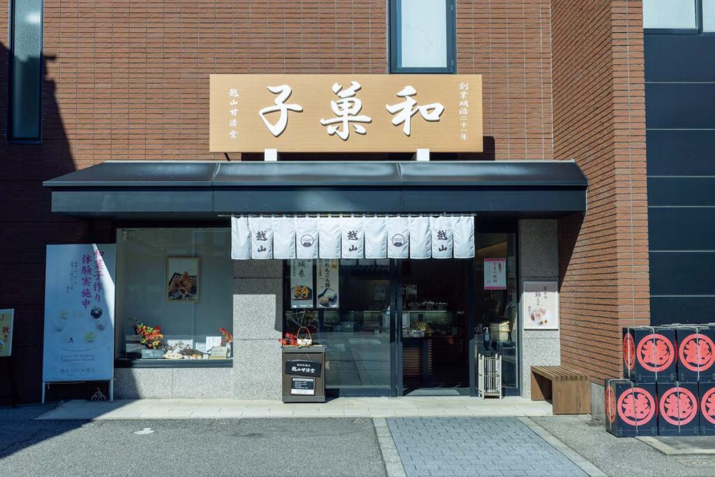 越山甘清堂_Koshiyama Kanseido_尾張町
1888年に甘納豆専門店として創業。砂糖が手に入りやすくなった戦後以降、生菓子も作り始めた。五色生菓子もその頃から。起源自体は江戸時代に遡るといわれ、婚礼や建前などで配られる祝い菓子で、日、月、山、海、里を表した5 種の菓子が詰まっている。「見た目もかわいくて、あんこをいろいろな形で味わえるのも嬉しい。それぞれに込められた意味を知ると、金沢の菓子文化の奥深さにますます興味が湧きました」。五色生菓子は1 週間くらい前までに要予約。▷本店／石川県金沢市尾張町2‒11‒28 ☎076‒255‒6610 9:00～17:30 カフェ10:30～18:00 水休
写真： 尾張町の大通り沿い。