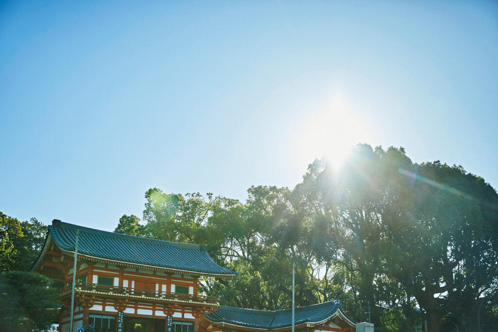 早朝の祇園。八坂神社の西楼門に木漏れ日が降り注ぎ、昼間とは違って、凛とした空気を纏っている。