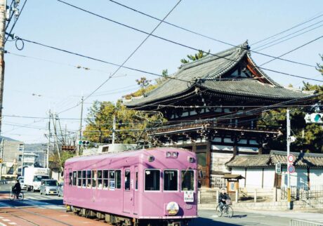 嵐電
1910年に開通して以来、嵐電の名で親しまれる京福電気鉄道。京紫色と呼ばれる車両の色は100周年を機に採用されたイメージカラー。写真は広隆寺の楼門の前を走る嵐電。