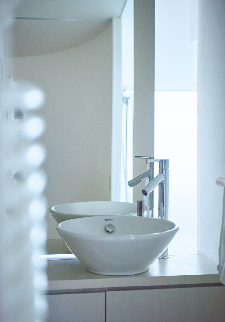 洗面台の鏡は、トイレと脱衣所の 壁を兼ね、用途に応じ開閉可能に。
