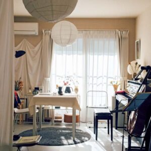 和紙で作られた球体のペンダントランプシェードは、〈IKEA〉で購入。ベージュトーンの壁紙の面積を少なくするため、窓の左側の壁に白い布を張りつけた。