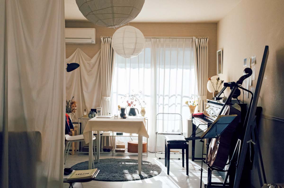 和紙で作られた球体のペンダントランプシェードは、〈IKEA〉で購入。ベージュトーンの壁紙の面積を少なくするため、窓の左側の壁に白い布を張りつけた。