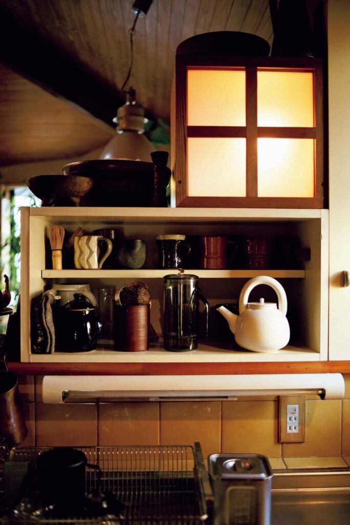 キッチンにも作り付けの棚や照明が。民藝の器や、アメリカの作家の茶器などが仲良
く並んでいる。