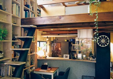 リビングからキッチンを望む。「海外のインテリア雑誌で見かけた『壁を一面、本棚にして、いろいろなものを置く』はやってみたかったんです」