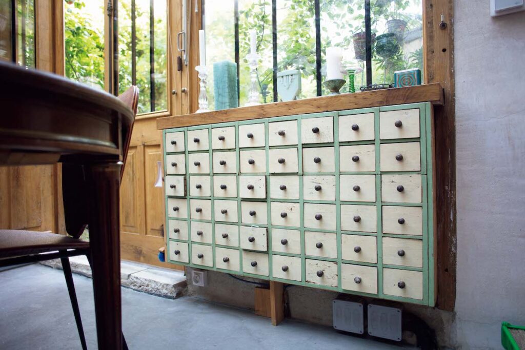 ニコラの実家がある、ノルマンディー地方のヴィッドグルニエで購入した棚。マッチやろうそく、碁石などこまごまとしたものを収納。