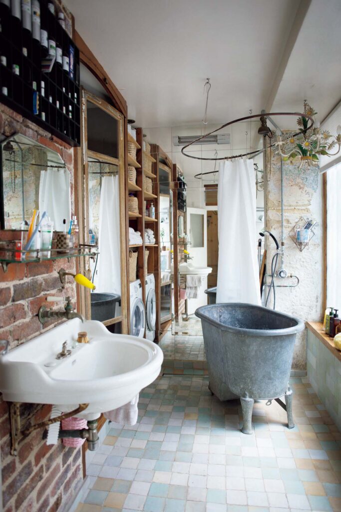 バスルーム。ボンコワンで見つけた浴槽は、べニョワール・ド・サボと呼ばれる古いもの。中に座れて、床も温まる。洗面台の鏡、壁に取り付けた棚もヴィンテージ。タイルはモロッコのフェズで購入した。