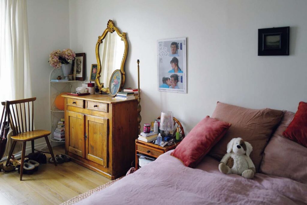 ベッドルームのリネンはローズ系でコーディネート。家具はアルザスの実家から運んだもの。鏡横の絵は義妹からの贈り物。