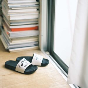 〈ニック ホワイト〉オリジナルシャワーサンダル | 山藤：主にミッドセンチュリー期の家具や雑貨を扱う、東京・青山にあるインテリアショップのオリジナルサンダル。シャワー用だが、ベランダにも、ルームシューズとしても使える。「外に置いたままのベランダサンダルは、陽にさらされて色も褪せるので、消耗品と割り切ってその時々の気分で気になったものを購入します。機能性を重視して、スポーツブランドやアウトドアブランドのものを選ぶことが多いですが、こんなふうにシンプルな中にもちょっとした遊び心があるタイプが好みです」。￥3,960（ニック ホワイト ☎03‒3407‒3110）