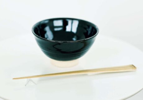 遠藤：碗／三重県伊賀市を中心に作られている伊賀焼。「黒飴」とは釉薬名のことで、釉薬をかけていない高さのある高台も特徴的。「ひとつひとつ厚みや釉薬のかかり具合が違うのも味。黒地に白米がよく映えます」。￥3,740　箸／素材は、肌目や節の入り方が美しく、扇子や茶道具によく使われる真竹。奈良県生駒市の竹細工職人が削り出す。「すっと角が立つように削られた美しい竹箸は、豆や魚の骨も扱いやすい。食べるだけでなく摑むという〝作業〞を楽しむ日用品としての〝道具〞感もいい」。￥1,980（ともに東屋 ☎03‒6433‒7980）