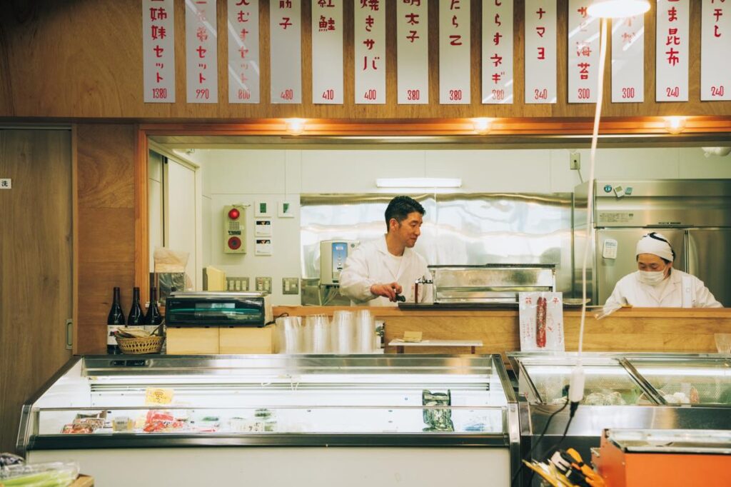 山形の食といえば、とローカルの人々が揃って薦めてくれたのが『エンドー』（山形市長町2−1−33）。昭和40（1965）年から営業する町のスーパーでありながら、小板橋さんが「その枠組みをとっくに飛び出している」と話すように、名物はイートインのげそ天だ。日本海で獲れたスルメイカを米油で揚げ、衣はサクサク、中はふっくら。油が軽く、箸が止まらない。
スーパーマーケットとして、鮮魚や惣菜も販売するほか、リキュールや果汁ジュース、乾麺などお土産も見つかる。左が3代目の遠藤英則さん。