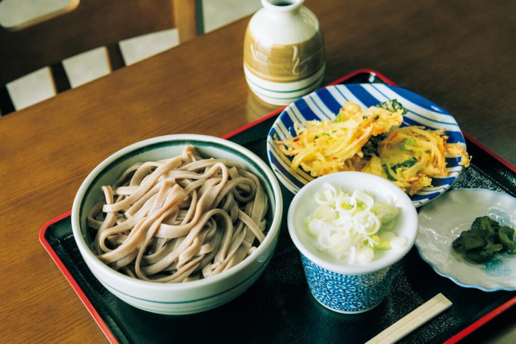 太さの違う平麺がつゆに絡む『浪花亭』（東村山郡山辺町山辺1090−3）のきそば（￥750）と天ぷら（￥200）。一度閉店したが、今は店主の孫が打ち台に立つ。