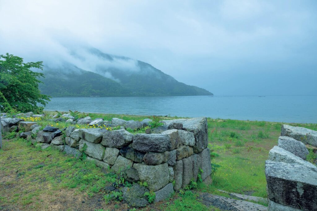 滋賀・奥琵琶湖で聖なる水辺を歩く旅。後編 | 『魚治』のある高島市の海津は、湖上交通の要衝として栄えた、琵琶湖沿いにある宿場町。湖岸には、波風から家を守る目的で江戸時代に築かれた石積みが残り、独自の景観をつくっている。