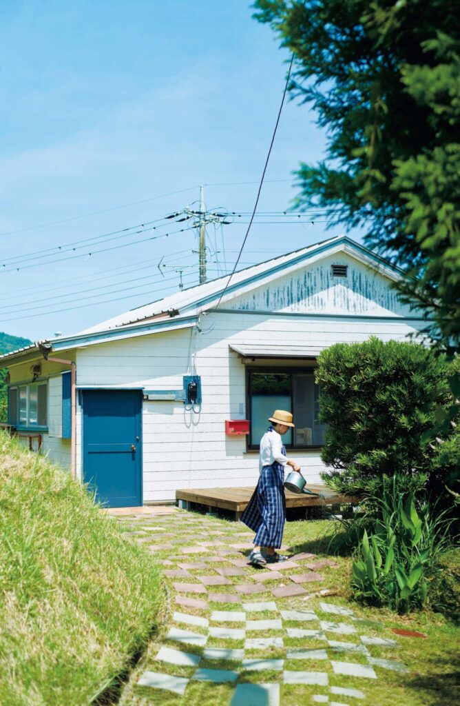 真っ青な空に白い壁が映えるおおいしれいこさん、久米大作さんの平屋。石畳は大作さんが手作りした。