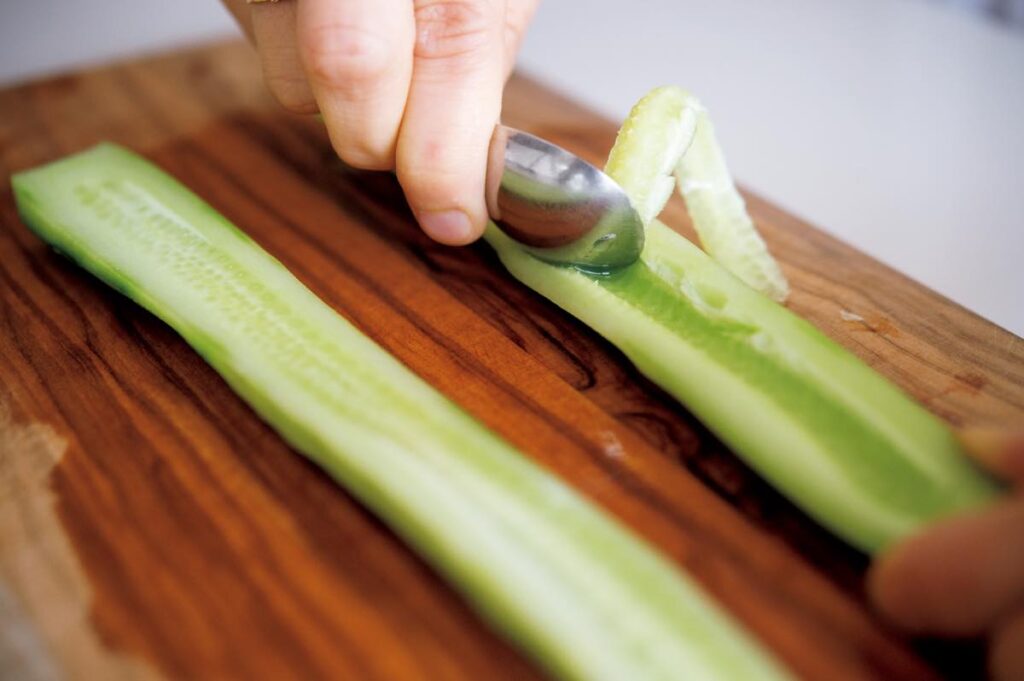 キュウリの種はスプーンを使ってこそげ取る。皮と種がないとより良い食感に。