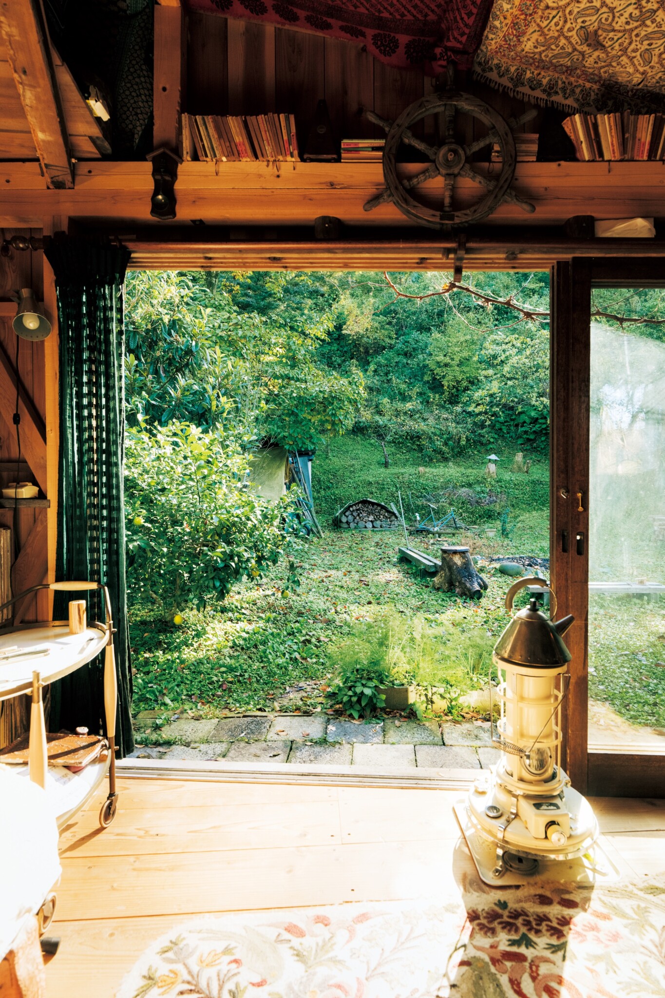 複雑化せず、ひとつの空間に収める。音楽家・高砂隆太郎さんが暮らす、10㎡の小屋。 | 調理器具としても活躍してくれるストーブ。暖房はほかにホットカーペットとエアコンもある。南向きに入り口となるガラス戸を設置。