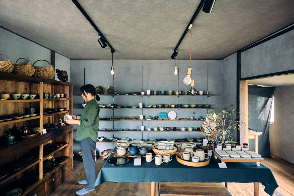 東京から尾道へと移住し「うつわとくらしの道具カルフ」を開店した樋熊敏亨さん。店内の棚やテーブルには、各地から選りすぐった日本の作家のものが並ぶ。