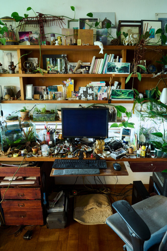 作家の市川拓司さんの書斎は、まるで植物園のよう。縦横無尽な植物と共生しながら創作をしている。机上にはパソコンのほか、工具、絵の具、自作の木製玩具、オブジェなどが。