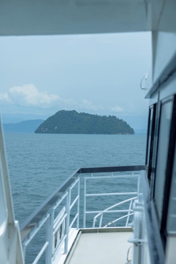 滋賀・奥琵琶湖で聖なる水辺を歩く旅。前編 | 島全体がパワースポットの、竹生島。「深緑 竹生島の沈影」は琵琶湖八景の一つ。竹生島には湖西の今津港と湖東の長浜港からクルーズ船が出ており、所要時間は片道いずれも30分ほど。