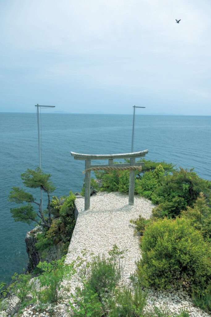 滋賀・奥琵琶湖で聖なる水辺を歩く旅。前編 | 『都久夫須麻神社』の龍神拝所。湖に向かって立つ鳥居に土器を投げて願掛けをする。