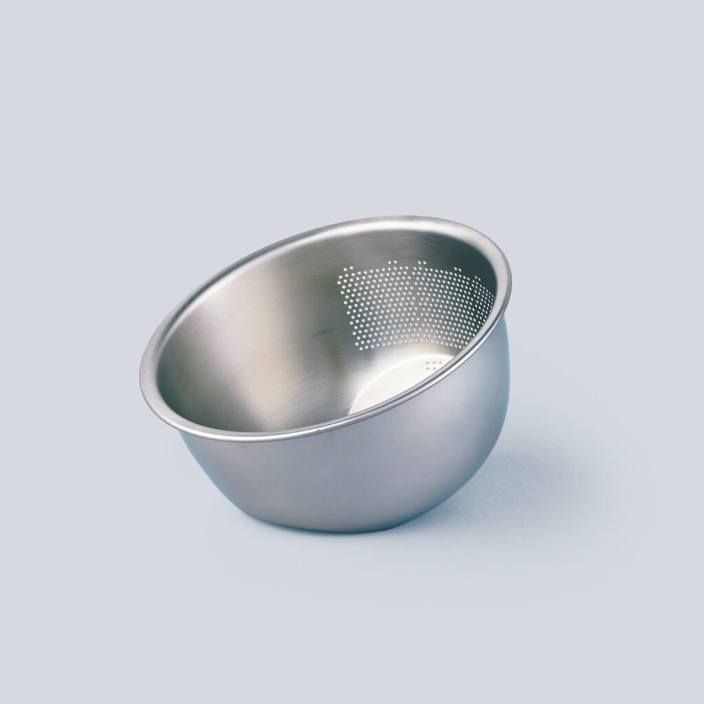 〈藤井器物製作所〉の 3WAY水切りボウル／底面の傾斜と片方の側面の穴により、水にさらす、きる、和えるがボウル一つで賄える。「米とぎはもちろん、野菜を洗う、水きりする、茹でたものを水きりする、和える、という一連の作業がこれ一つでOK」。［∅23.2×H12.1㎝］￥2,970 (藤井器物製作所 ☎0256−63−8330) 修復家・河井菜摘さんが教えてくれた、＋αで料理がぐっと楽しくなる道具。新生活のための、ショッピングマニュアル。