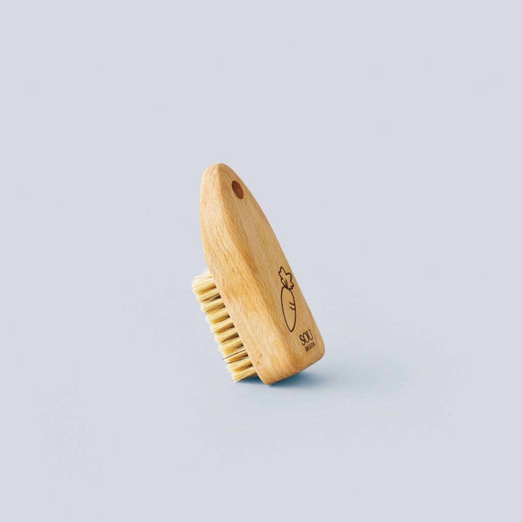 〈ソウ アカダ〉の根野菜ブラシ／人参の刻印が愛らしい根菜用のブラシ。「たわしだと当たりがきつすぎたり、まんべんなく汚れを落とせなかったりしますが、これはどんな形状でもフィットして、皮を傷めずに細かいところまで洗えます。ごぼうの味が変わりました」。￥2,079 (赤田ブラシ ☎0573−79−2541) 修復家・河井菜摘さんが教えてくれた、＋αで料理がぐっと楽しくなる道具。新生活のための、ショッピングマニュアル。
