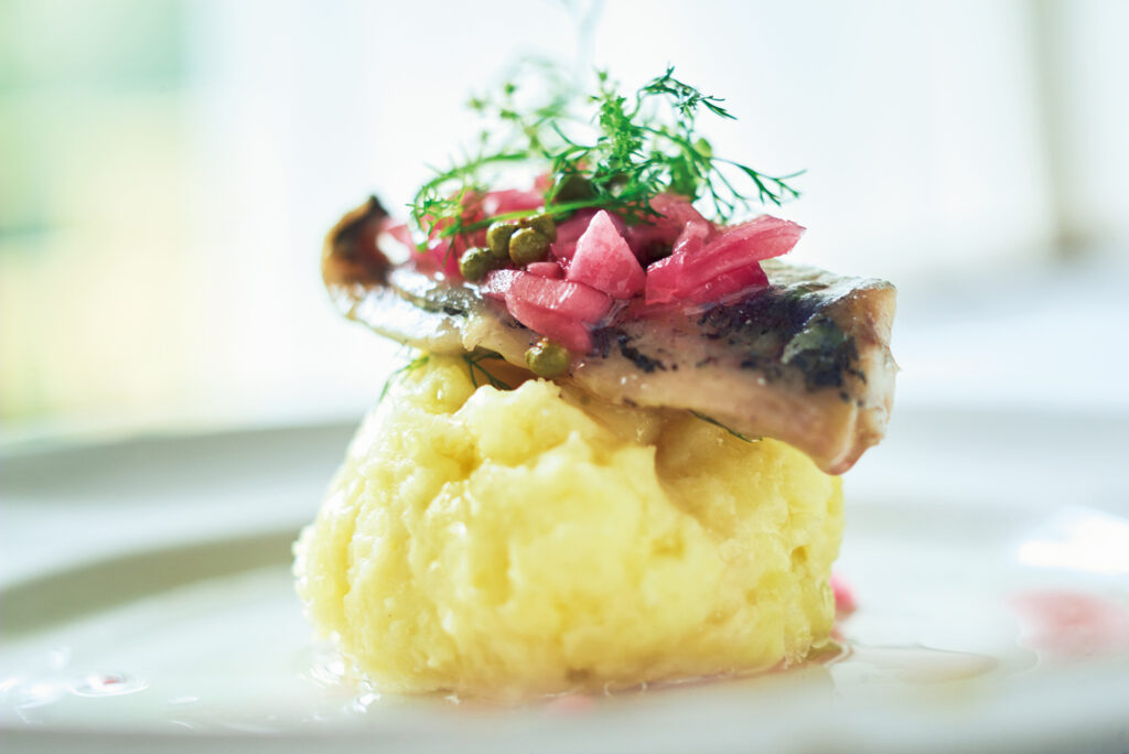 鯵のオイル漬けをのせたポテトサラダ。鯵の身をほぐして、混ぜて食べる。紫玉ネギの酢漬けのピンクが愛らしい。料理家・中川たまさんが教える、アレンジ自在の保存食で作る、爽やかな夏料理。
