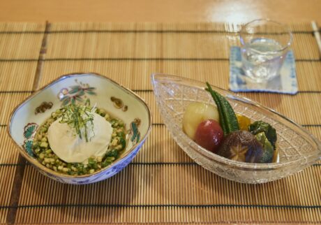 左の南禅寺と呼ばれる丸い豆腐は、鶴岡の夏の風物詩。外内島 (とのじま) きゅうりをはじめとした8種の地元の野菜を細かく刻んだ郷土料理・だしを添えた、南禅寺と鶴岡のだし (￥600) 。右の夏野菜の揚げ浸し (￥600) にも民田なすをはじめ、鶴岡産野菜を使っている。
