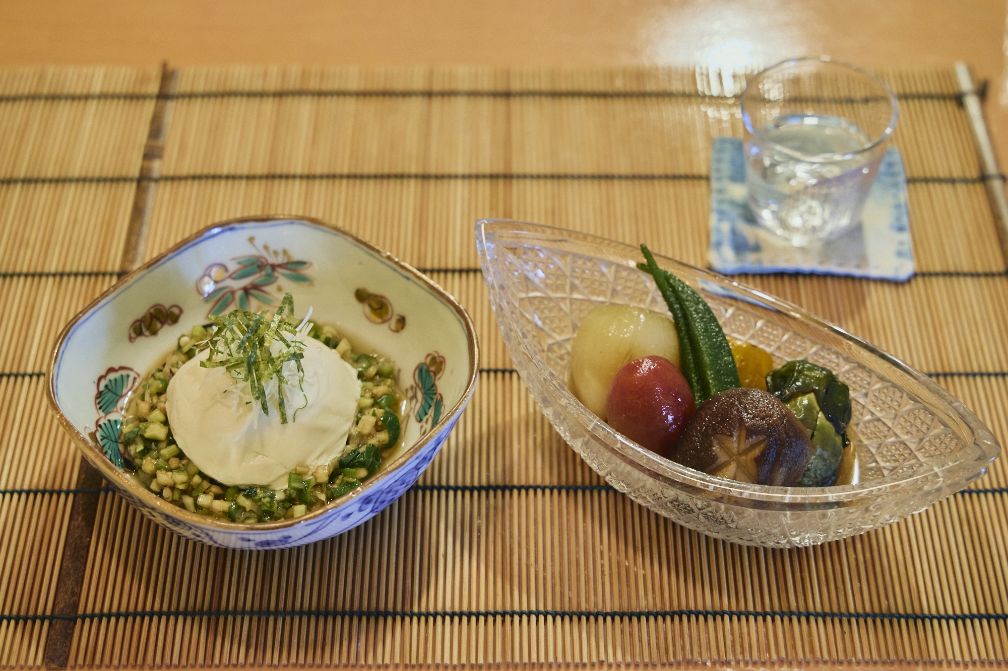 左の南禅寺と呼ばれる丸い豆腐は、鶴岡の夏の風物詩。外内島 (とのじま) きゅうりをはじめとした8種の地元の野菜を細かく刻んだ郷土料理・だしを添えた、南禅寺と鶴岡のだし (￥600) 。右の夏野菜の揚げ浸し (￥600) にも民田なすをはじめ、鶴岡産野菜を使っている。