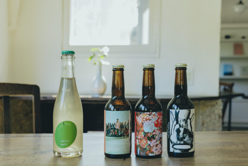 左／栃木県産のりんごを使用した、ナチュールシードル (グラス¥900、ハーフボトル357ml ¥1,500) 。右／カフェから徒歩数分の場所に店舗を構える〈ミンゲル〉のクラフトビール (各330ml ¥900) 。左から、柑橘とトロピカルな風味の「ワークインオット」、とちおとめの香りを酸味が広がる「ストロベリー レター 25」、セゾン酵母で醸した黒ビール「シェイズ オブ ジェイ」。 | 左／栃木県産のりんごを使用した、ナチュールシードル（グラス¥900、ハーフボトル357ml ¥1,500）。右／カフェから徒歩数分の場所に店舗を構える〈ミンゲル〉のクラフトビール（各330ml ¥900）。左から、柑橘とトロピカルな風味の「ワークインオット」、とちおとめの香りを酸味が広がる「ストロベリー レター 25」、セゾン酵母で醸した黒ビール「シェイズ オブ ジェイ」。